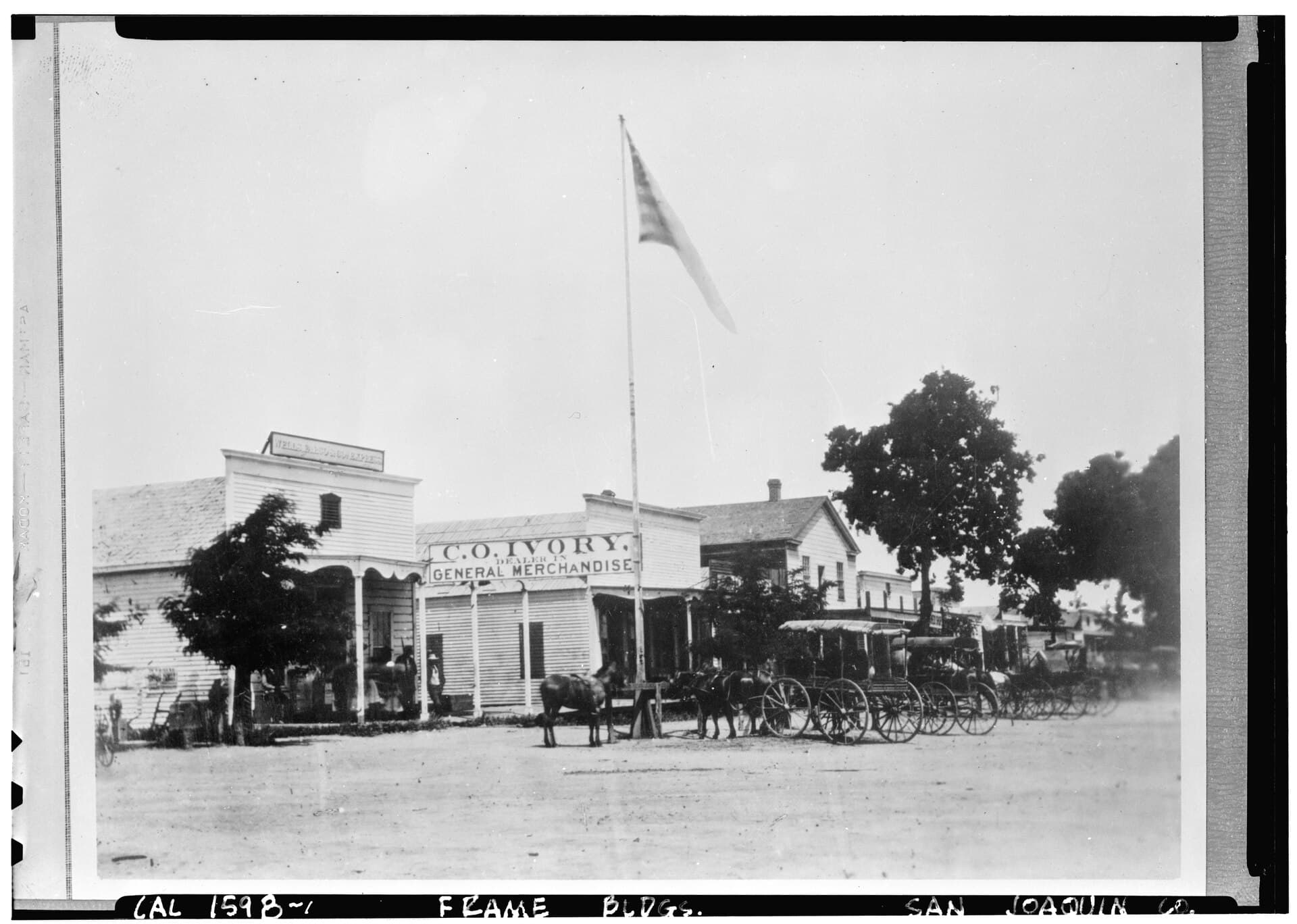 Historic black-and-white view of Lodi storefronts, carriages, and pedestrians